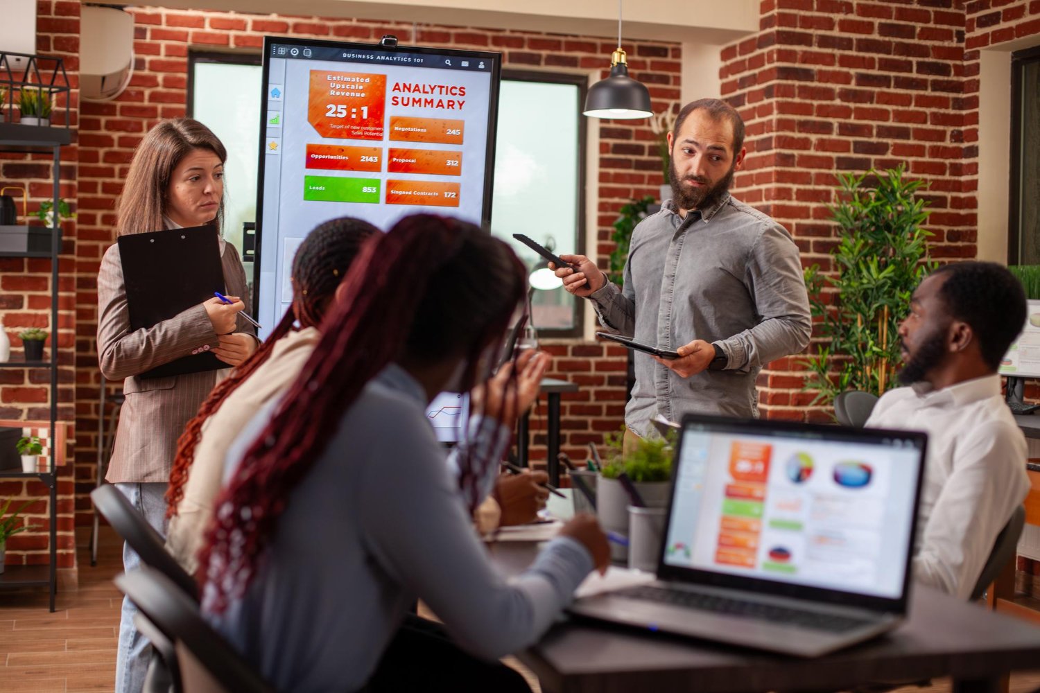 Business team analyzing digital data together in modern office setting