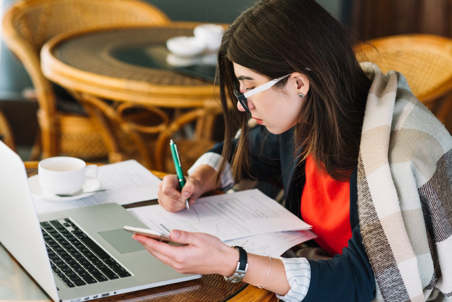 Businesswoman using a laptop in a coffee shop for content writing services and digital projects