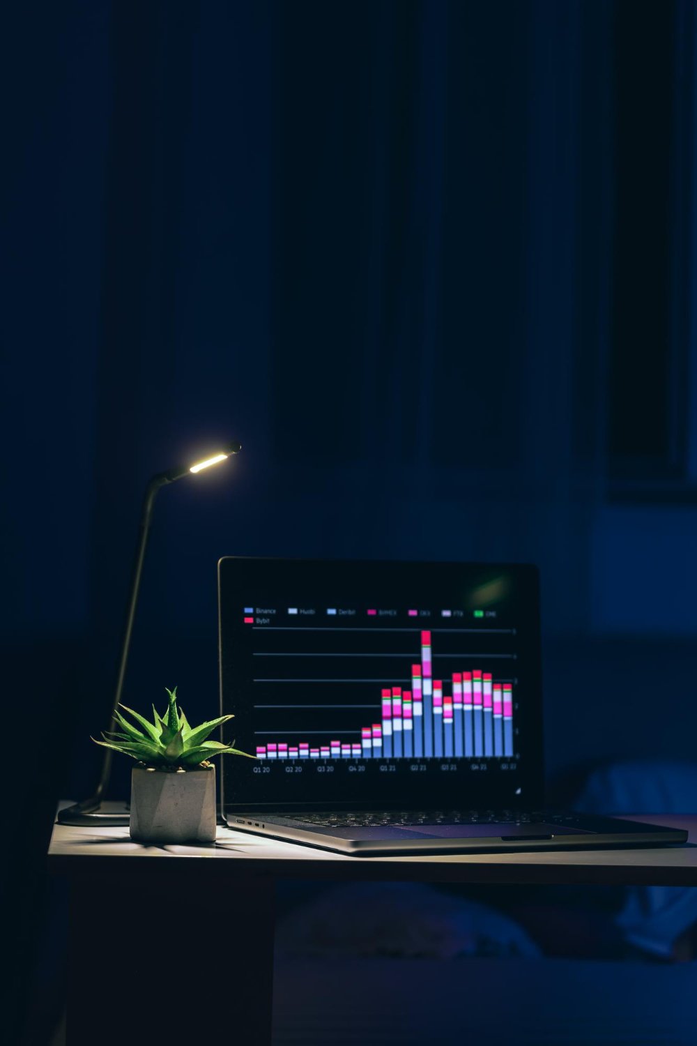 Computer in a dark room displaying analytics graphs on screen for data analysis and business insights