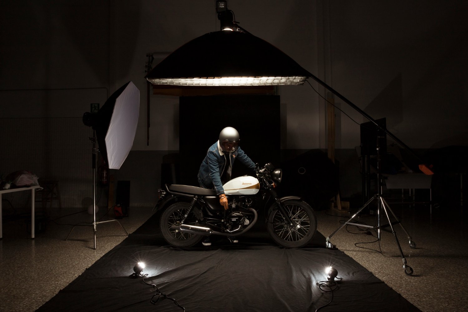 Man posing with a cafe racer motorbike in a professional product photography setup